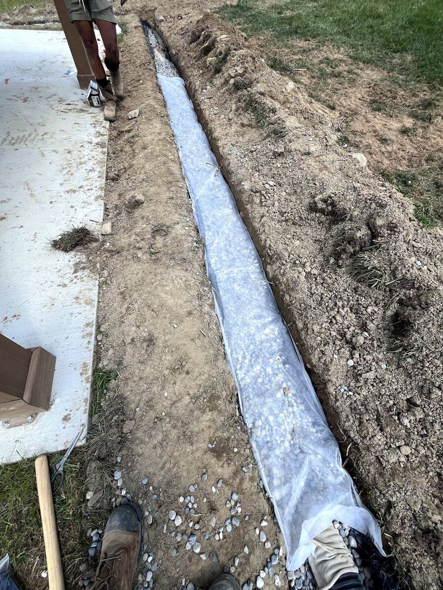 Drainage tile installation behind a wall